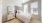 Bright bedroom with two large windows furnished with night stand, mirror and bed
