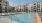 Clsoe up of pool with loungers and building in the background